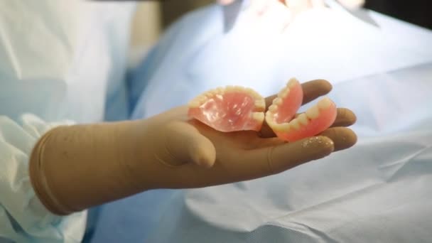 Zbliżenie Dłoni Chirurga Dentysty Trzymającego Sztuczne Szczęki Które Usunął Pacjentowi — Wideo stockowe