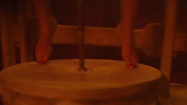 暗い雰囲気の部屋で彼女の素足で車輪を回転させる陶芸家の女性のクローズアップ — ストック写真