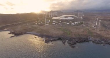 Rüzgar türbinlerinin deniz kenarındaki hava görüntüsü. Gün batımında 4K hava çekimi. 4k drone görüntü türbinleri