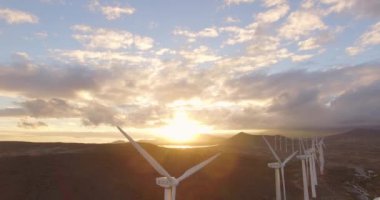 Rüzgar türbinlerinin deniz kenarındaki hava görüntüsü. Gün batımında 4K hava çekimi. 4k drone görüntü türbinleri