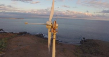 Rüzgar türbinlerinin deniz kenarındaki hava görüntüsü. Gün batımında 4K hava çekimi. 4k drone görüntü türbinleri