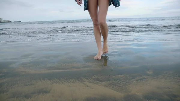 砂浜で踊る女性の足 美しい女性がビーチを歩いている 砂の上で足を閉じて — ストック写真