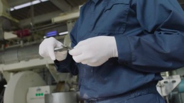 Köpekler ve kediler için gıda üretiminin kalite kontrol süreci. Çalışan ürünün kalitesini ve boyutunu kontrol eder.