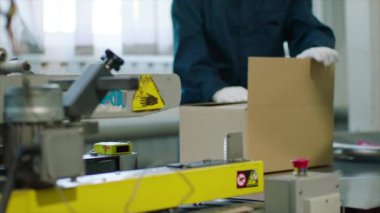 Karton bir kutuyu taşıma bandı hattında kapatmak. Dağıtım deposu. E-ticaret hizmeti, depolama, teslimat ve ambalaj kavramı.