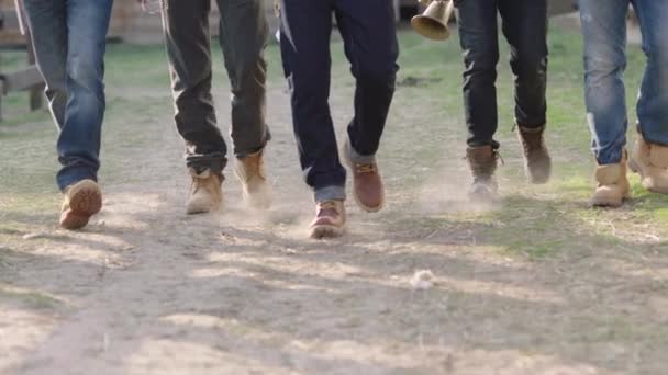 Benen Van Verschillende Mannen Jeans Bruine Laarzen Die Een Onverharde — Stockvideo