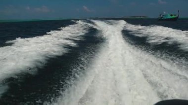 Gemi uyanıyor. Tekneden manzara hareket ediyor. Bir tekneden geniş bir uyanış. Dikiz aynası. Okyanus suyu. Koyu mavi. Gemiden iz..