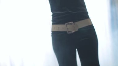 Zarif dişi, arka planda dumanla dans ediyor. Siyah elbiseli güzel bir kızın vücudunun merkez kısmına yakın plan..