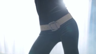 Zarif dişi, arka planda dumanla dans ediyor. Siyah elbiseli güzel bir kızın vücudunun merkez kısmına yakın plan..