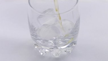 Buzlu bir bardak viski. Şişeden bardağa alkol dökülüyor. Buzlu viski. Kaydırıcı atışı. Koyu, kırsal, arka plan.