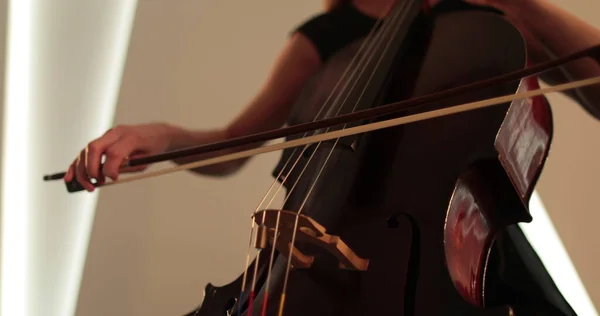 チェロ クローズアップ ミディアムアップ チェロの弓と弦を演奏する独身女性 フォーカスからアウトフォーカスへのカメラの円滑な移行 美しい映画 芸術的なショット — ストック写真