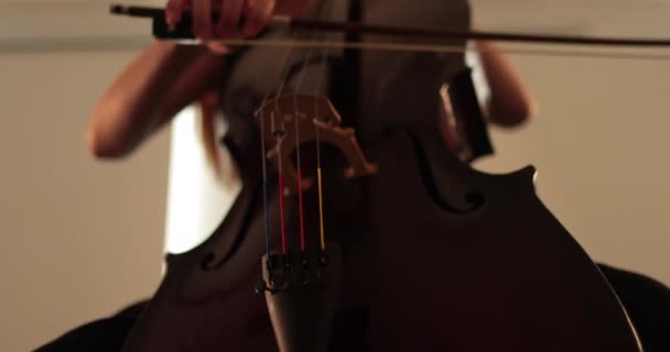 첼로를 연주하는 클로즈업 클로즈업 활로와 초점에서 밖으로 부드럽게 이동하는 카메라 — 비디오