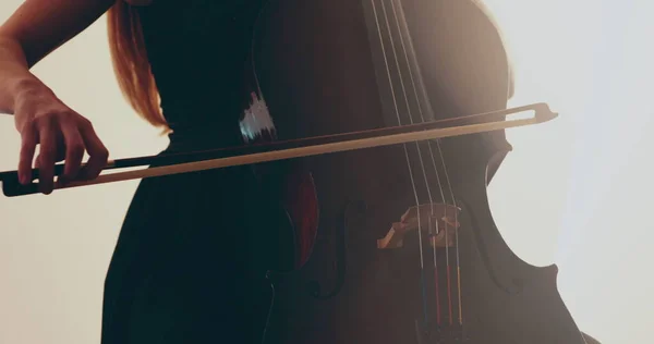 チェロ クローズアップ ミディアムアップ チェロの弓と弦を演奏する独身女性 フォーカスからアウトフォーカスへのカメラの円滑な移行 美しい映画 芸術的なショット — ストック写真