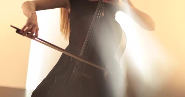 チェロ クローズアップ ミディアムアップ チェロの弓と弦を演奏する独身女性 フォーカスからアウトフォーカスへのカメラの円滑な移行 美しい映画 芸術的なショット — ストック動画