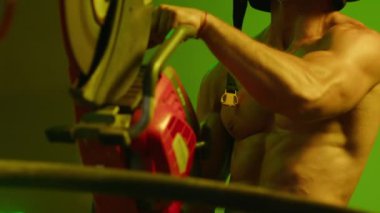 İtfaiyeci fitness modeli, metal kesme makinesiyle metal kesen itfaiyecinin yakın çekimi..