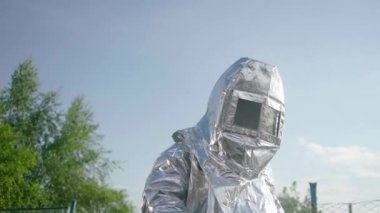 Isı yansıtıcı kıyafetli bir itfaiyeci, bir itfaiyeciyi yüksek sıcaklıklardan korur, özellikle de yüksek sıcaklıktaki bir ateşin yanında..