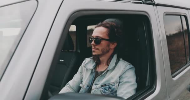 Jovem Está Sentado Carro Volante Com Óculos Sol Uma Jaqueta — Vídeo de Stock