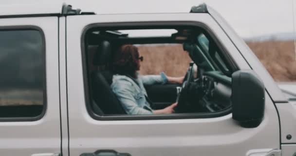 Jovem Está Sentado Carro Volante Com Óculos Sol Uma Jaqueta — Vídeo de Stock