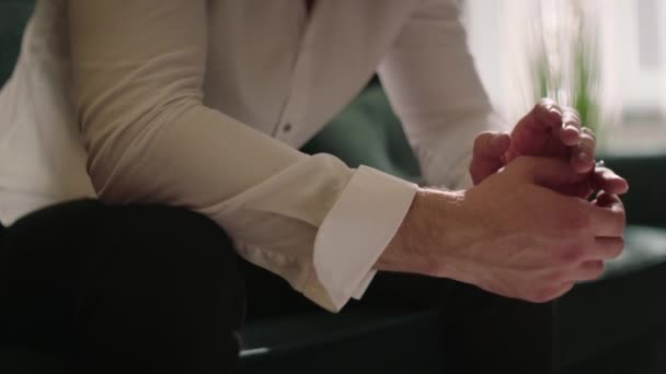 Ein Mann Weißen Hemd Mit Hochgekrempelten Ärmeln Sitzt Hände Vordergrund — Stockvideo