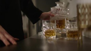 Güzel bir kadın elleri sürahide balmumu dökerek bir ev ya da otel ortamında bir bardağa döküyor. Renk düzeltmesi olmayan çekim, film kalitesi. Yüz tanıma olmadan yakın plan.