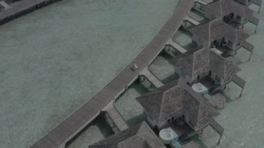 Beyaz elbiseli bir kız, bir otel bungalovunun yakınındaki ahşap bir köprü boyunca yürüyor. Maldivian adası tatil köyü. Maldivler. Cennette yaz tatili. Renk düzeltmesi olmayan görüntü.