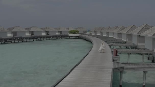 Girl White Dress Walks Wooden Bridge Hotel Bungalow Maldivian Island — Stock Video