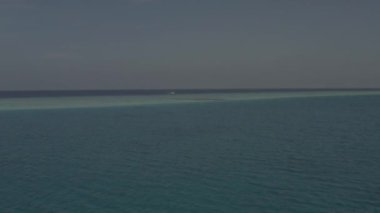 Bir İHA 'dan Maldivler' in güzel manzarası. Maldivler 'deki egzotik adaların, tatil beldelerinin ve manzaraların hava fotoğrafları. Adaların kuş bakışı manzarası, plajlar, mavi su, beyaz kum. Renk düzeltmesi olmayan video.