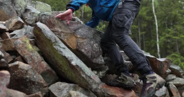 一个旅行者的腿爬上了岩石地形上的山 单身男性徒步旅行 — 图库视频影像