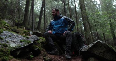 Bir gezgin yağmurlu havada ormanda bir gaz ocağında çay hazırlar. Yalnız bir gezgin metal bir kupadan çay hazırlar ve içer.