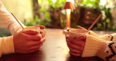Romantik bir buluşmada bir kafede oturan birbirine aşık bir çiftin ellerinin yakın çekimi. Birbirine aşık bir çiftin romantik bir buluşmasında erkek ve kadın elleri birbiriyle etkileşime girer..