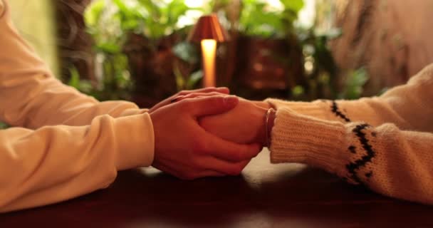 ロマンチックなデートのカフェでテーブルに座って恋に落ちたカップルの手のクローズアップ 恋するカップルのロマンチックな会議の瞬間にお互いに相互作用する男性と女性の手 — ストック動画