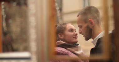 Birbirine aşık bir çiftin yansıması, bir sonbahar günü dışarıda beklerken şefkatle kucaklaşması. Güzel kız ve yakışıklı adam sarılıp öpüşüyor..