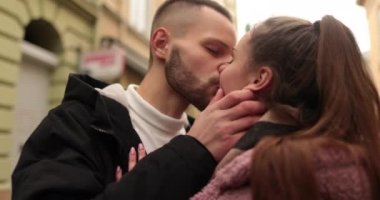 Aşık genç bir çiftin öpücükleri ve kucaklamaları. Kasvetli bir sonbahar gününde şehir merkezinde genç bir çiftin romantik bir buluşması. Mutlu erkek ve kız kucaklaşır, öpüşür, birlikte eğleniriz..