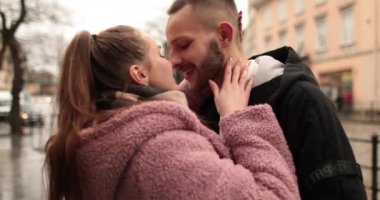 Aşık genç bir çiftin öpücükleri ve kucaklamaları. Kasvetli bir sonbahar gününde şehir merkezinde genç bir çiftin romantik bir buluşması. Mutlu erkek ve kız kucaklaşır, öpüşür, birlikte eğleniriz..