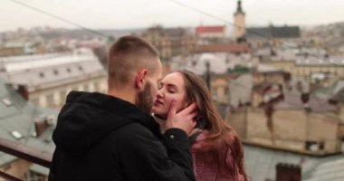 Aşık genç bir çiftin öpücükleri ve kucaklamaları. Kasvetli bir sonbahar gününde şehir merkezinde genç bir çiftin romantik bir buluşması. Mutlu erkek ve kız kucaklaşır, öpüşür, birlikte eğleniriz..