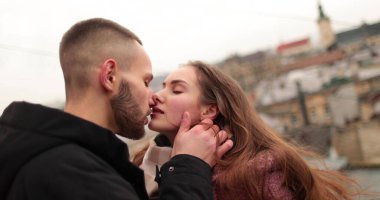 Aşık genç bir çiftin öpücükleri ve kucaklamaları. Kasvetli bir sonbahar gününde şehir merkezinde genç bir çiftin romantik bir buluşması. Mutlu erkek ve kız kucaklaşır, öpüşür, birlikte eğleniriz..