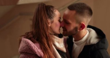 Aşık genç bir çift, bir apartmanın koridorunda romantik bir randevudan sonra ateşli öpücükler ve kucaklaşmalarla veda eder..