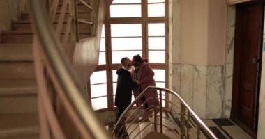 Eski bir apartmanın merdivenlerinde romantik bir veda, romantik bir randevudan sonra iyileşen bir çiftin genel fotoğrafı..