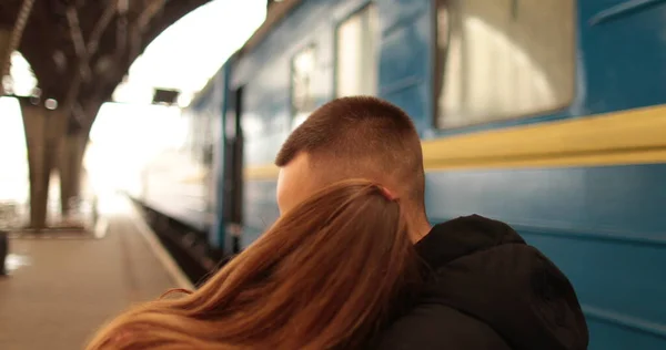 사랑에 커플은 포옹하고 여자가 기차에 도착하기 인사를 역에서 — 스톡 사진
