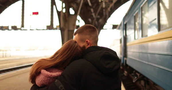 사랑에 커플은 포옹하고 여자가 기차에 도착하기 인사를 역에서 — 스톡 사진