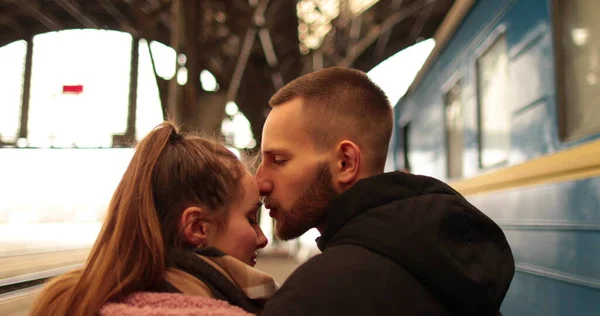 A young couple in love hug and say goodbye before the girl gets on the train to leave. Farewell at the station.