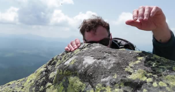 登山者尽自己最大的努力爬到山顶 克服岩石高度的时刻 从山上看登山者 — 图库视频影像