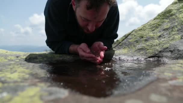 一个又渴又健康的游客跑上来 在恶劣的山区条件下从一个小水坑里喝水 山区生存概念 在山穷水尽的山穷水尽 — 图库视频影像