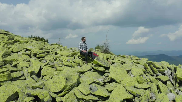 男はラップトップで働き 岩山の頂上に座っている 山での休暇中にリモート作業 世界中のリモートワークのコンセプト — ストック写真