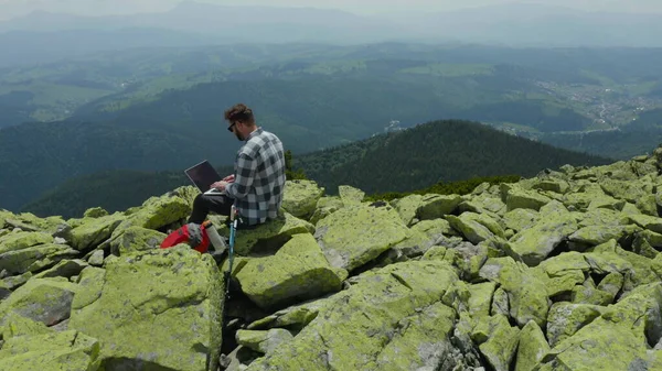 Hombre Trabaja Portátil Mientras Está Sentado Cima Una Montaña Rocosa — Foto de Stock