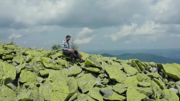 Homem Trabalha Laptop Enquanto Está Sentado Topo Uma Montanha Rochosa — Vídeo de Stock