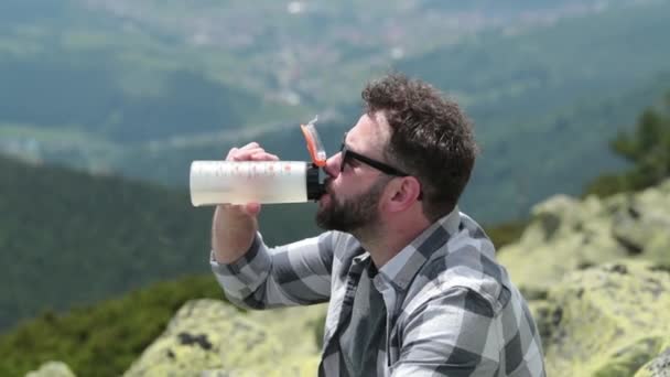 Muž Pije Vodu Láhve Když Sedí Skalnatém Svahu Člověk Pije — Stock video