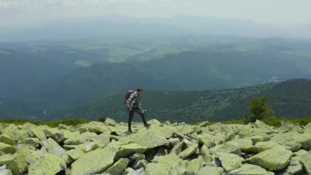 Ein Mann Geht Einem Mit Riesigen Steinen Bedeckten Berghang Entlang — Stockvideo