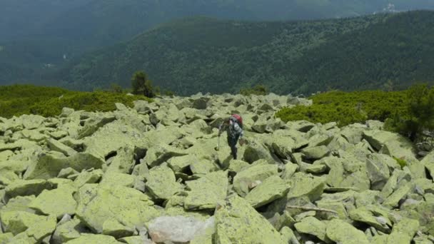 Ένας Άντρας Περπατά Κατά Μήκος Μιας Βουνοπλαγιάς Καλυμμένος Γιγάντιες Πέτρες — Αρχείο Βίντεο