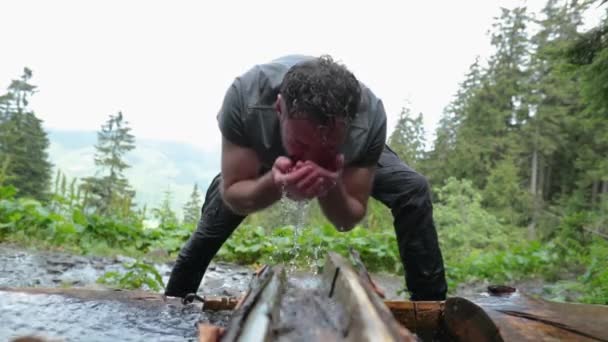 Ein Männlicher Tourist Steht Einem Gebirgsbach Wäscht Sich Das Gesicht — Stockvideo