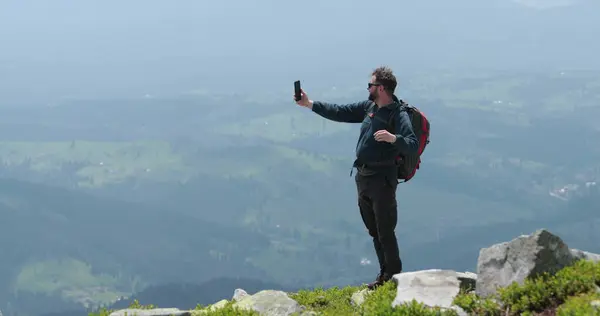 Dağın Tepesindeki Bir Gezgin Telefonla Konuşuyor Fotoğraf Çekiyor Görüntülü Konuşma — Stok fotoğraf
